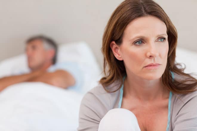 sad couple in bed