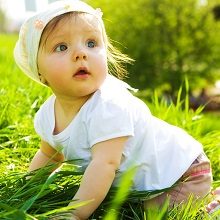 Baby crawling along grass