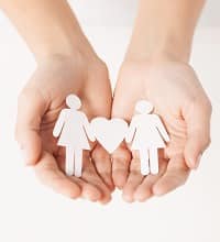 Hands holding cutout of lesbian couple