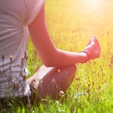 Woman meditating in meadow