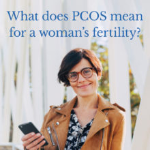 woman smiling holding phone - PCOS Blog image